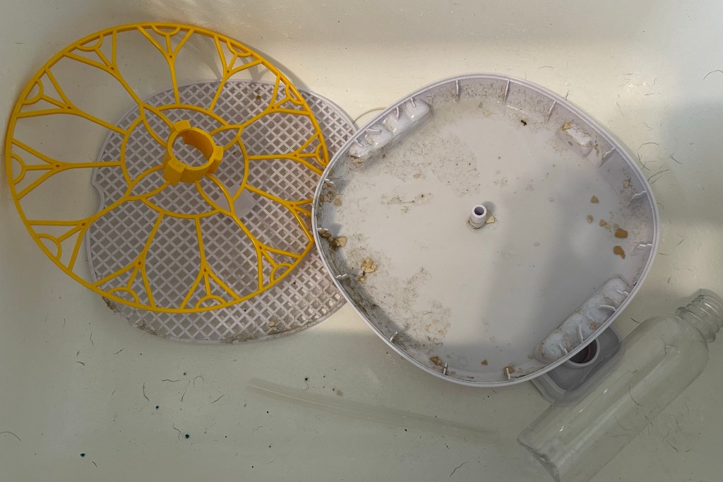 White and yellow dirty incubator parts in a white sink.