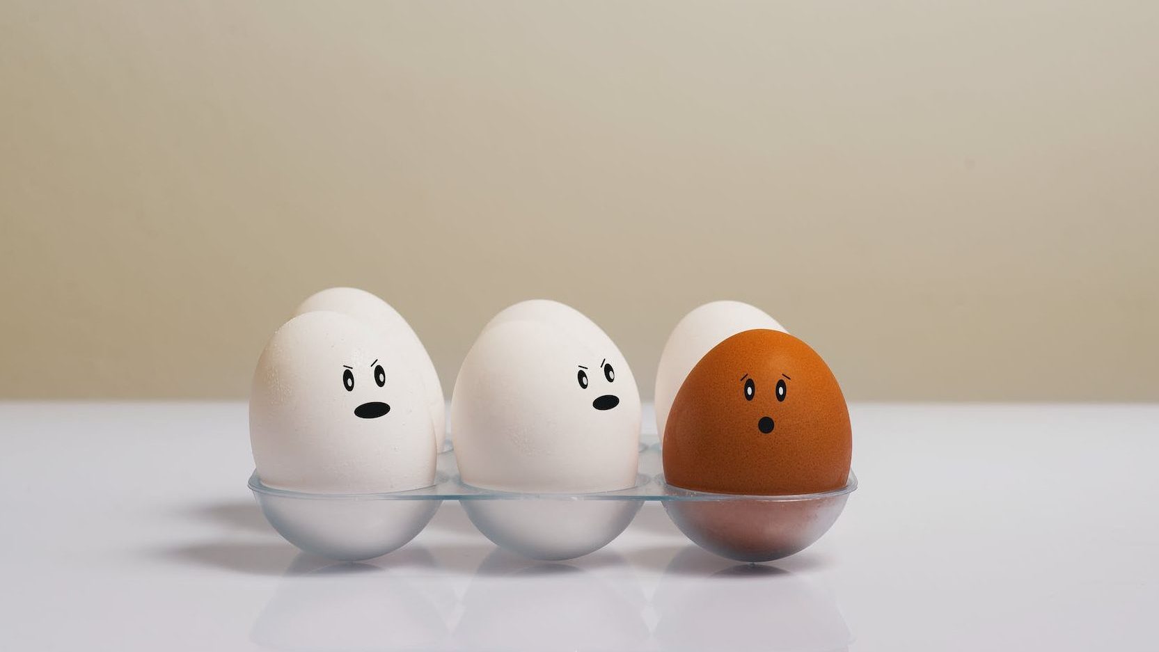 write eggs and one brown egg with facial emotions.