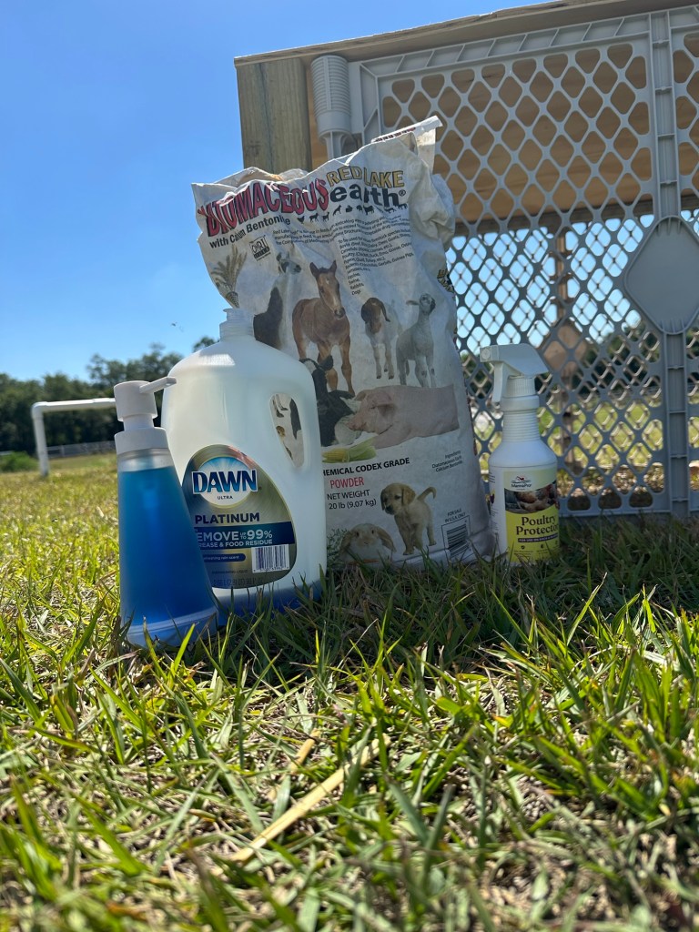 outside on the green grass is a 30lb bag, blue soap, white spray bottle and a plastic grey fencing.